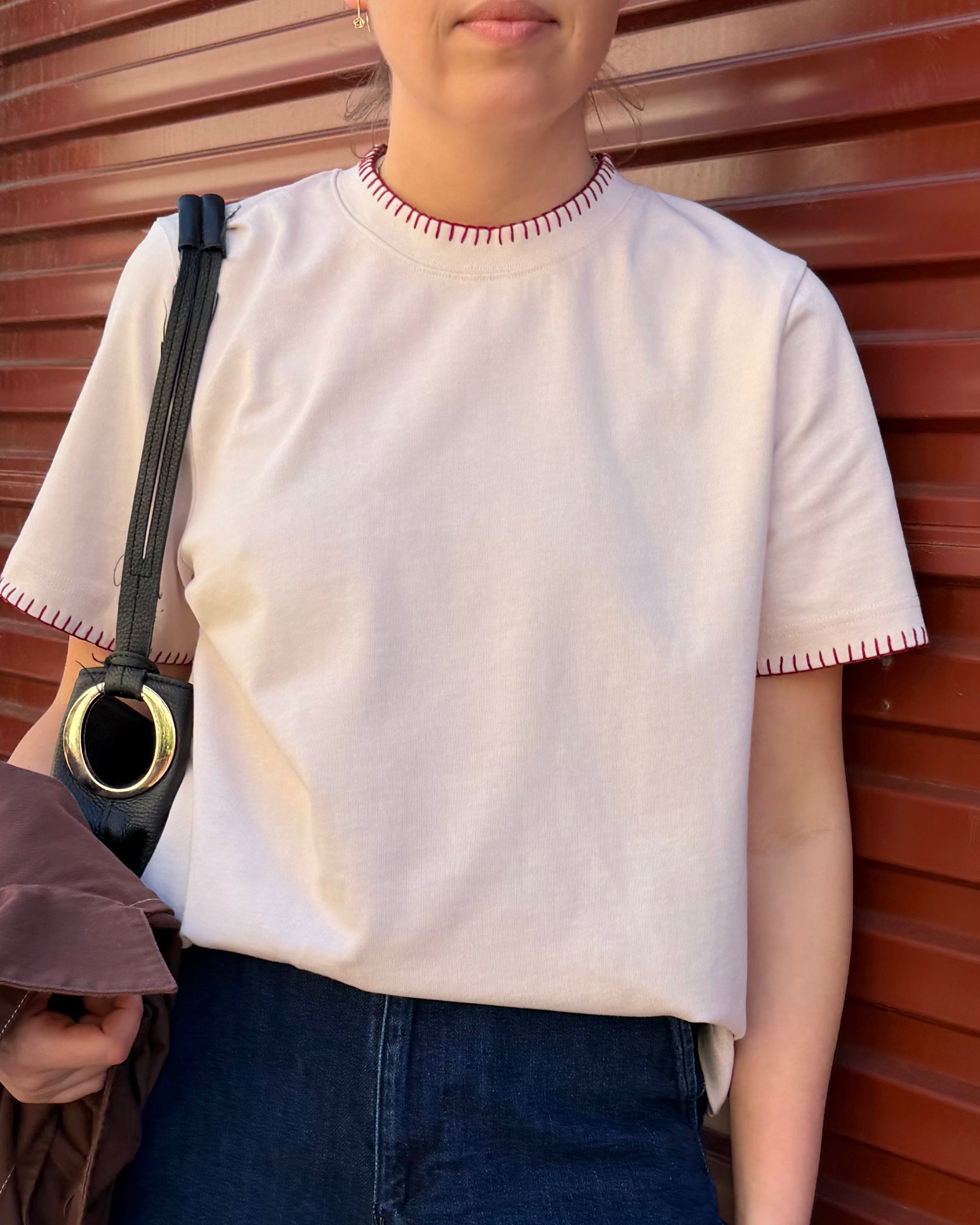 Say the Label Signature Tee in blush pink with contrast blanket-stitch trim, worn with denim