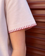 Close-up of the hand-stitched blanket-stitch cuff on the Signature Tee in blush pink