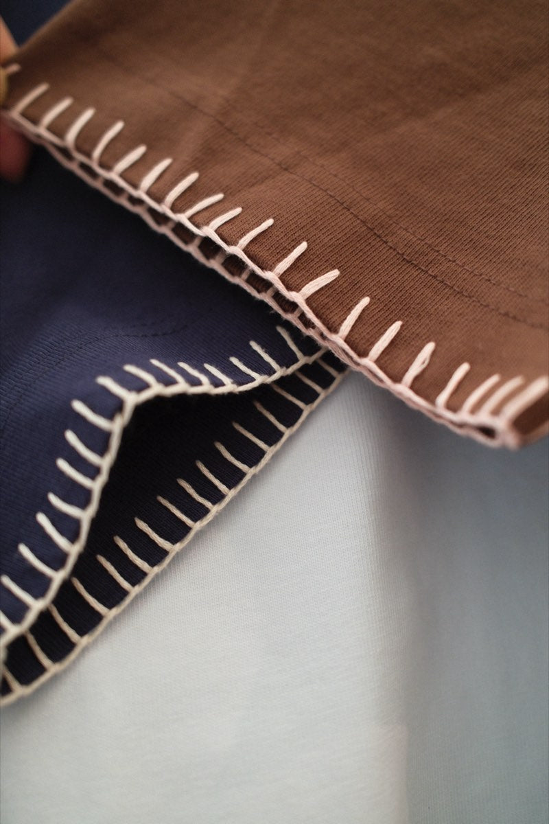 A blanket-stitched neckline in contrast thread